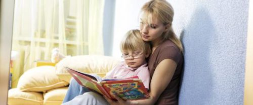 young mother reading from book to her son